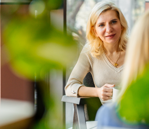 7N female staff members having a conversation while sitting down